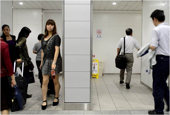 Slim men and women walking in and out of the Kyoto train station toilet